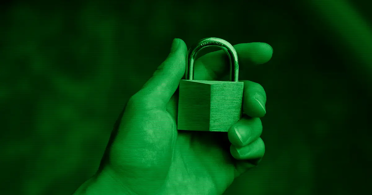 A hand holding a padlock, a symbol of cybersecurity