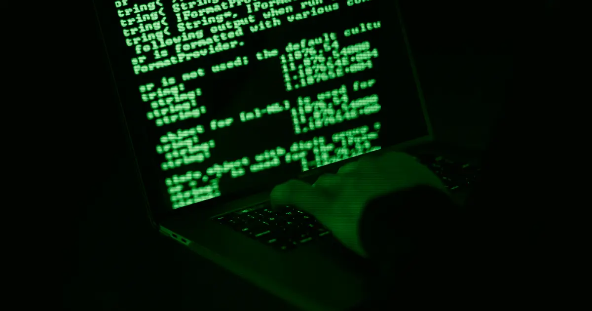 Hands typing on a laptop with information on the screen