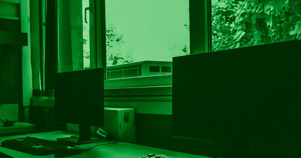 Modern computers on a desk next to a window