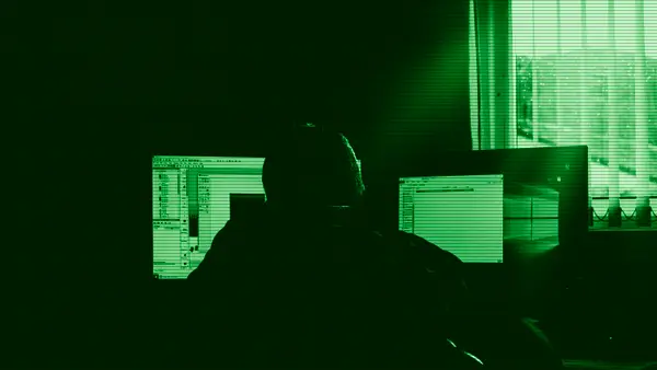 A person working in front of several computers
