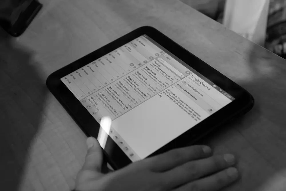 The HP TouchPad tablet running webOS 3.0 held in one hand